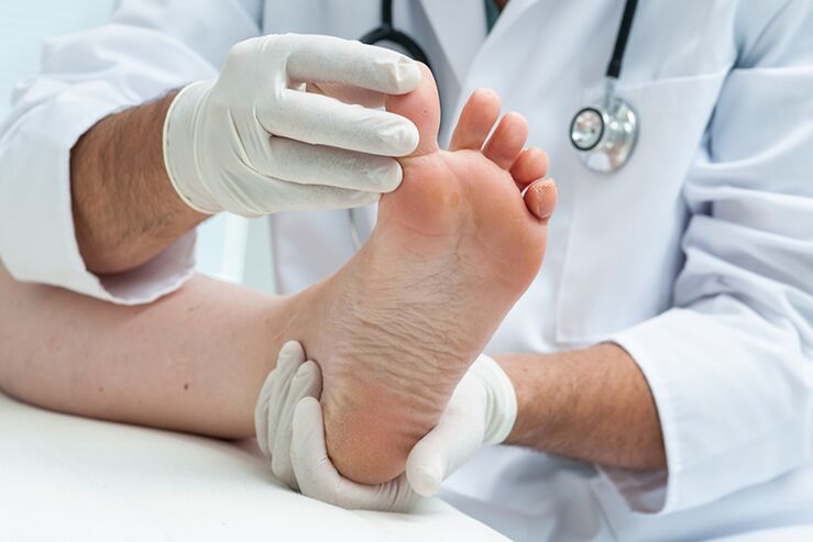O dermatólogo examina as pernas do paciente